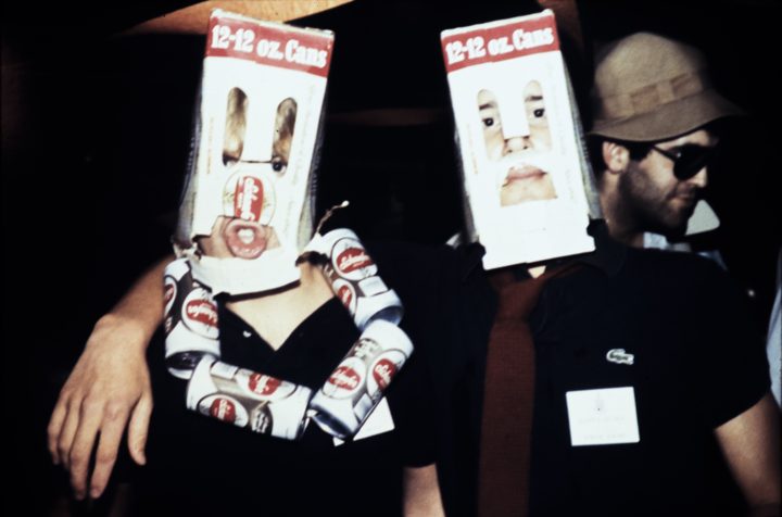 Two people at a party wearing paper masks