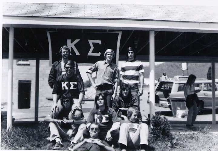 Black and white photograph of brothers on the porch and steps of the house, Kappa Sigma letters on the columns