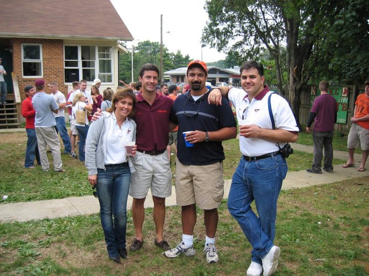 Four brothers and friends at a tailgate on a lawn